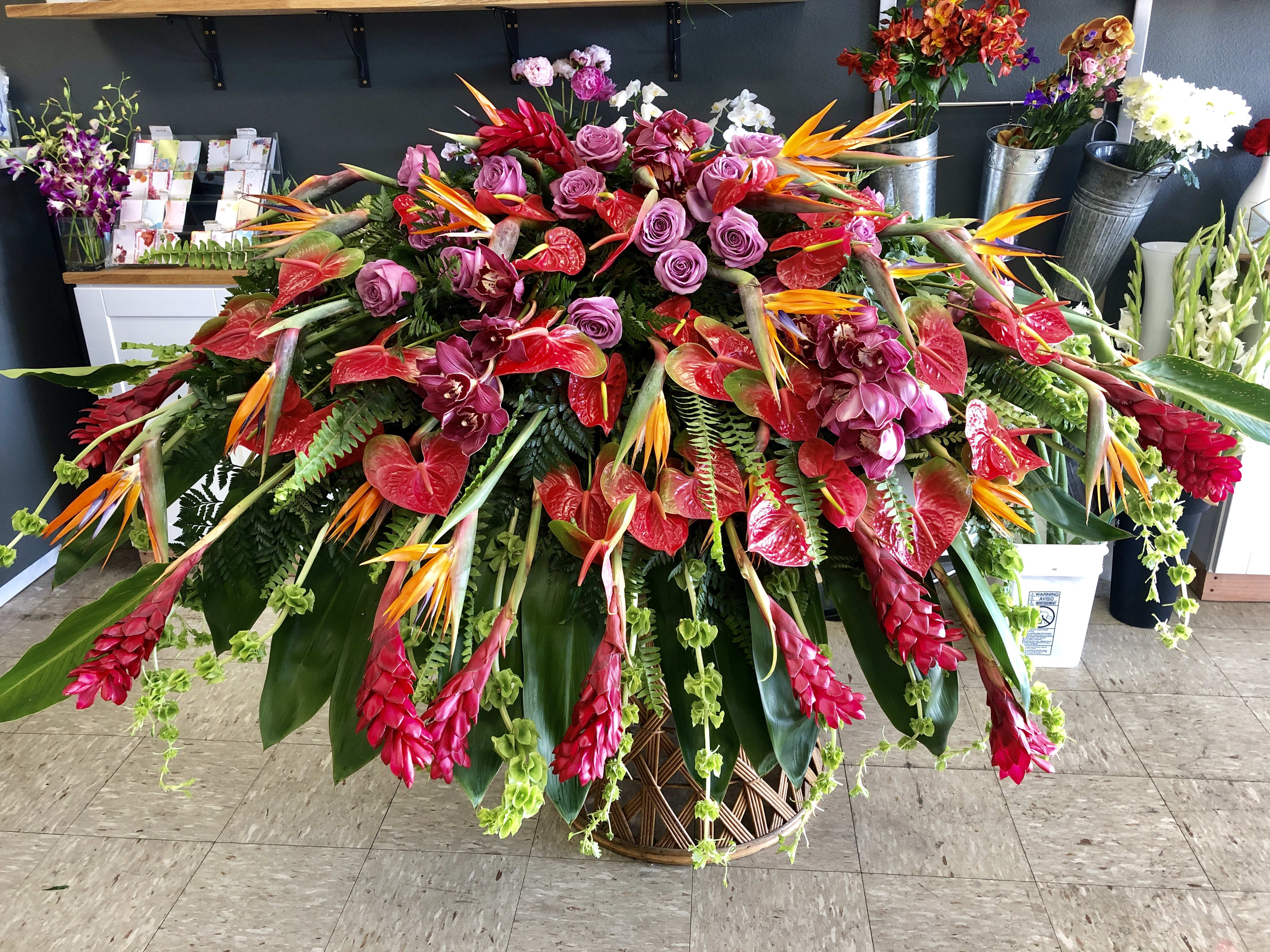 Large tropical floral arrangement in a woven basket