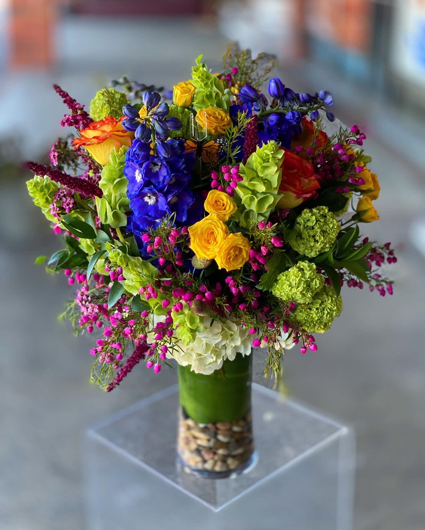 Everly - Tall Garden ( Designers Choice ) - A tall abundance of colorful seasonal blooms! PLEASE NOTE, YOUR ARRANGEMENT MAY NOT LOOK LIKE THIS PHOTO. THIS IS A SAMPLE OF WHAT WAS IN SEASON AT THE TIME. By selecting this item, you are selecting the design to be in a tall vase with a colorful color palette of mixed flowers that are in season. 