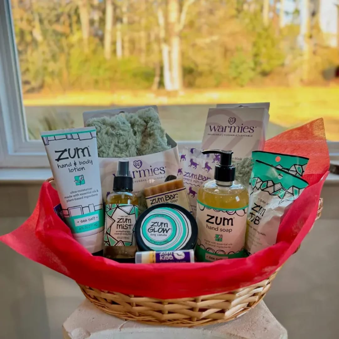 Basket of bath and body gift items wrapped in red tissue paper