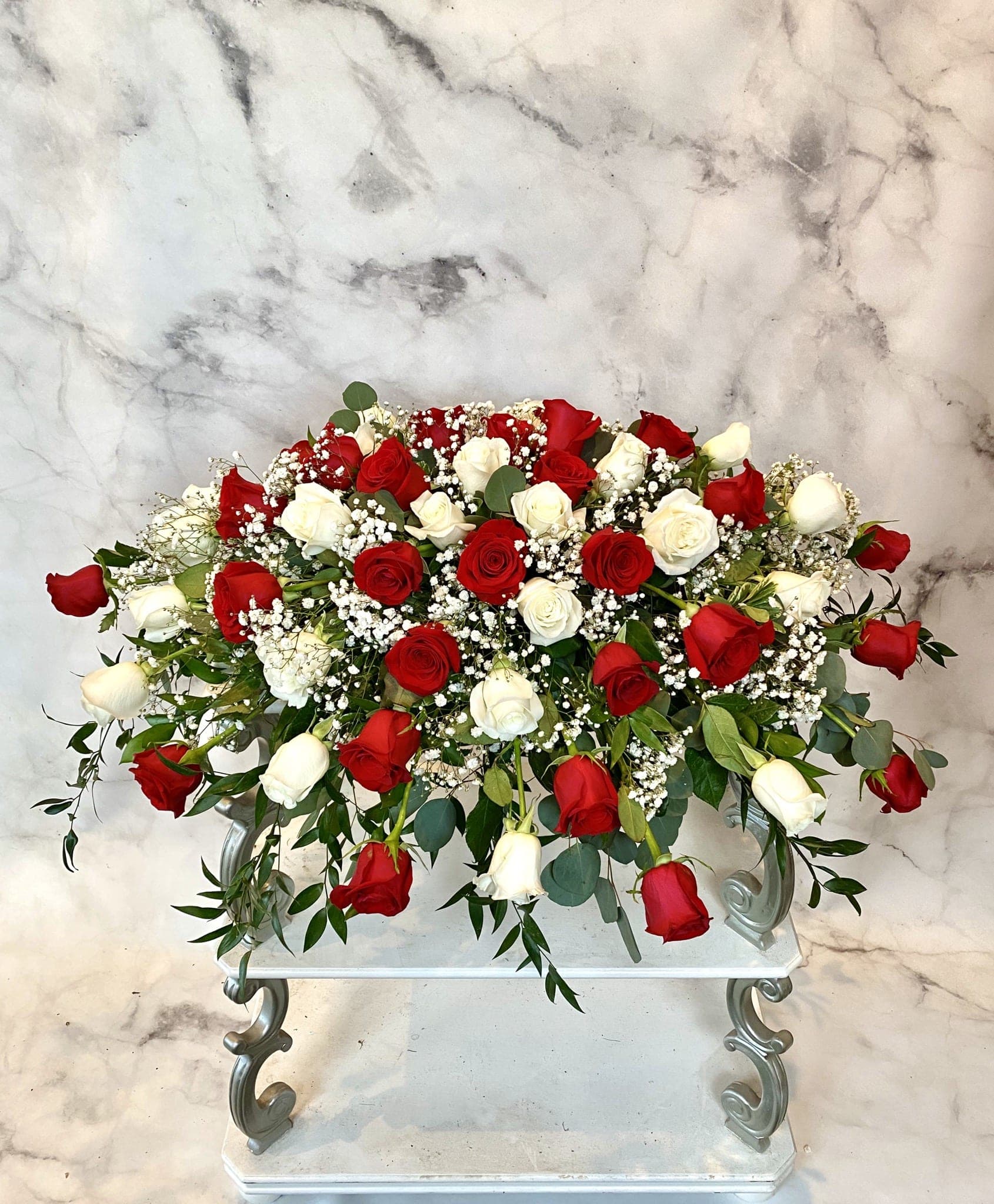 Large arrangement of red and white roses on a stand