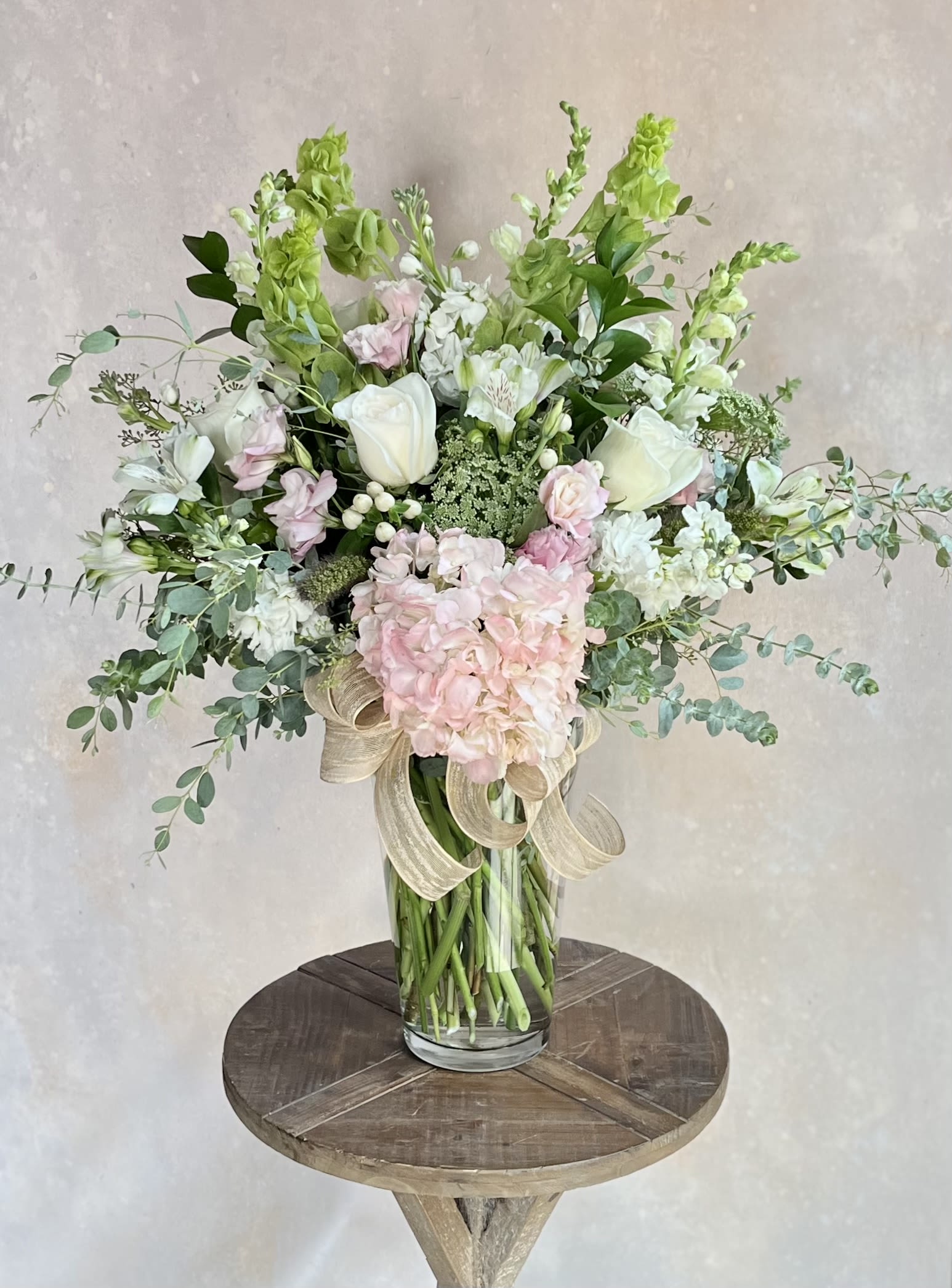 Tall bouquet of white and pale pink flowers in a glass vase