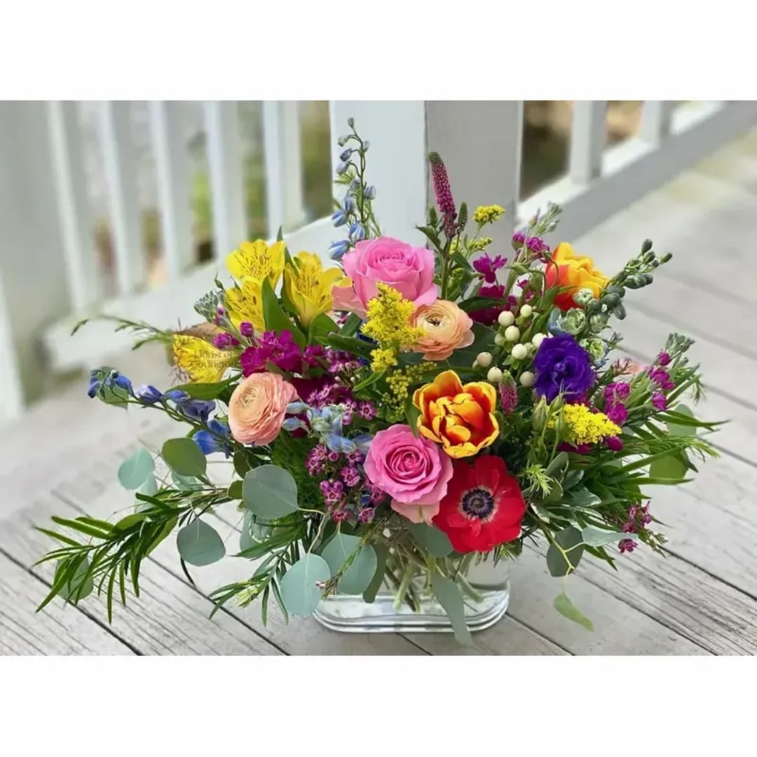 Mixed bouquet of colorful flowers in a clear glass vase