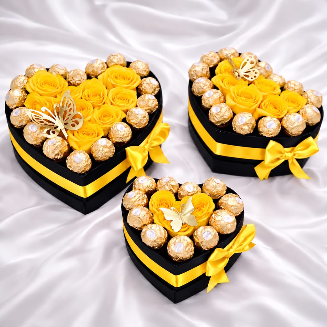 Heart-shaped gift boxes with yellow roses and chocolates on satin fabric