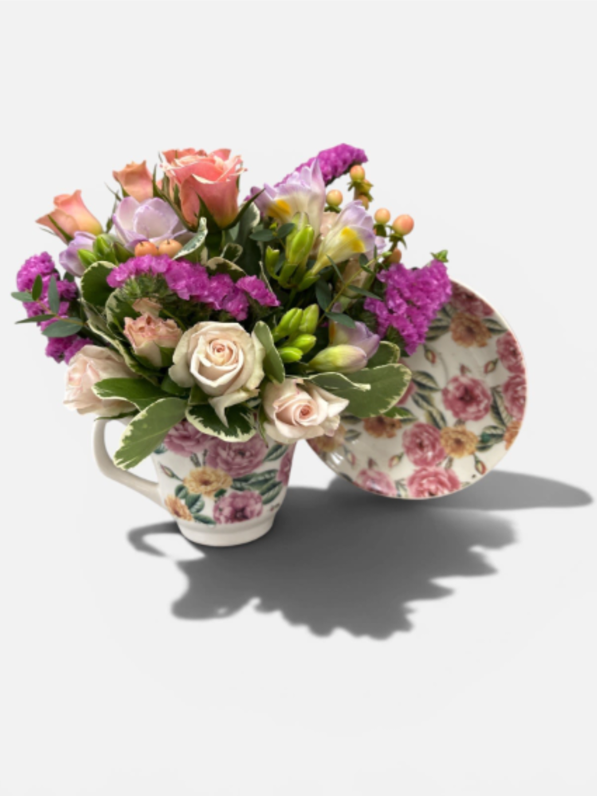 Floral arrangement in a floral teacup with pink and lavender blooms