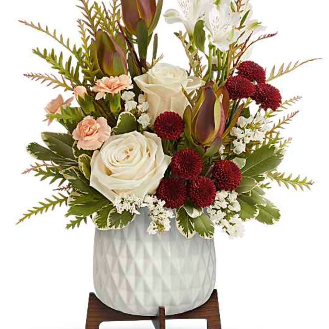 White and blush floral arrangement in a textured white vase
