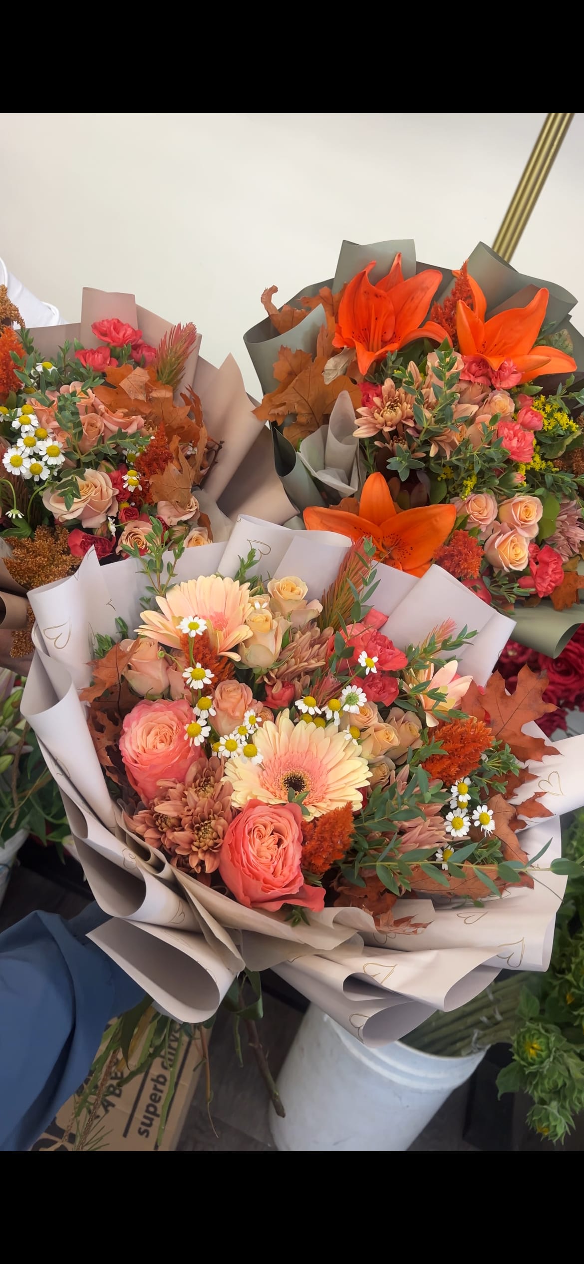 Fall in Bloom - Celebrate the changing seasons with our Fall in Bloom wrap bouquet, a hand-tied collection of autumn’s softest and warmest hues. Featuring a gentle blend of light and vibrant oranges, earthy browns, and golden fall leaves, this bouquet is wrapped in seasonal charm. **DELUXE PICTURED**