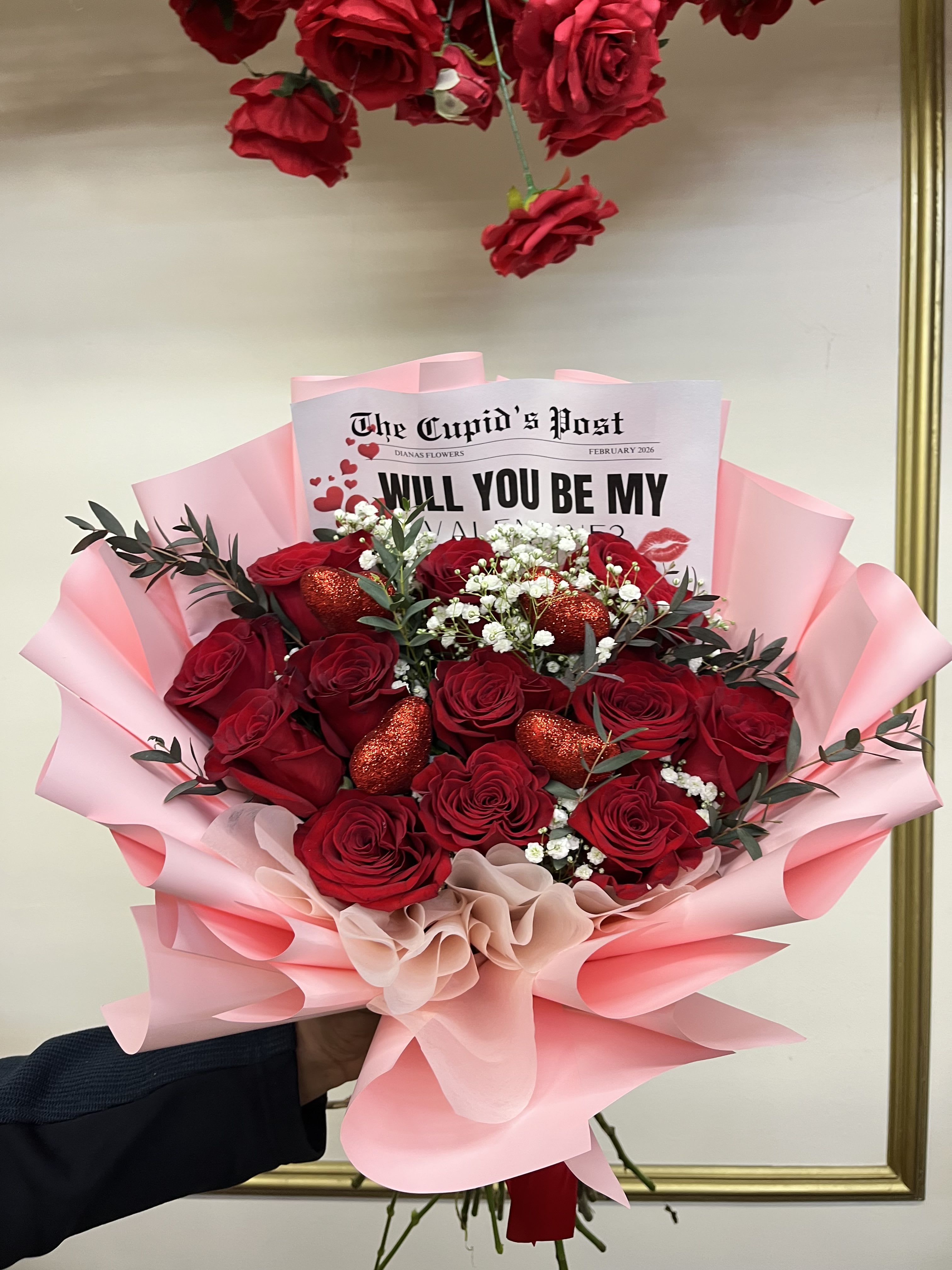 Bouquet of red roses with pink wrapping and a Valentine card