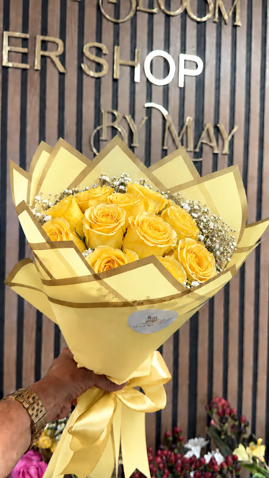 Yellow rose bouquet wrapped in pale yellow paper with a satin ribbon