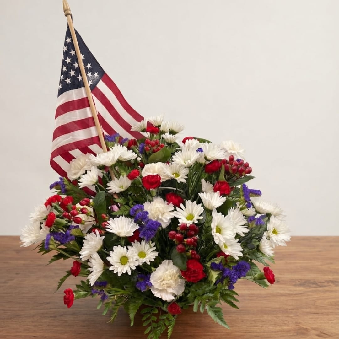 Red, white, and blue floral arrangement with an American flag