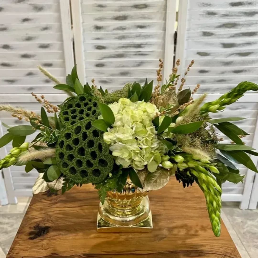 Green floral arrangement with hydrangea in a glass vase