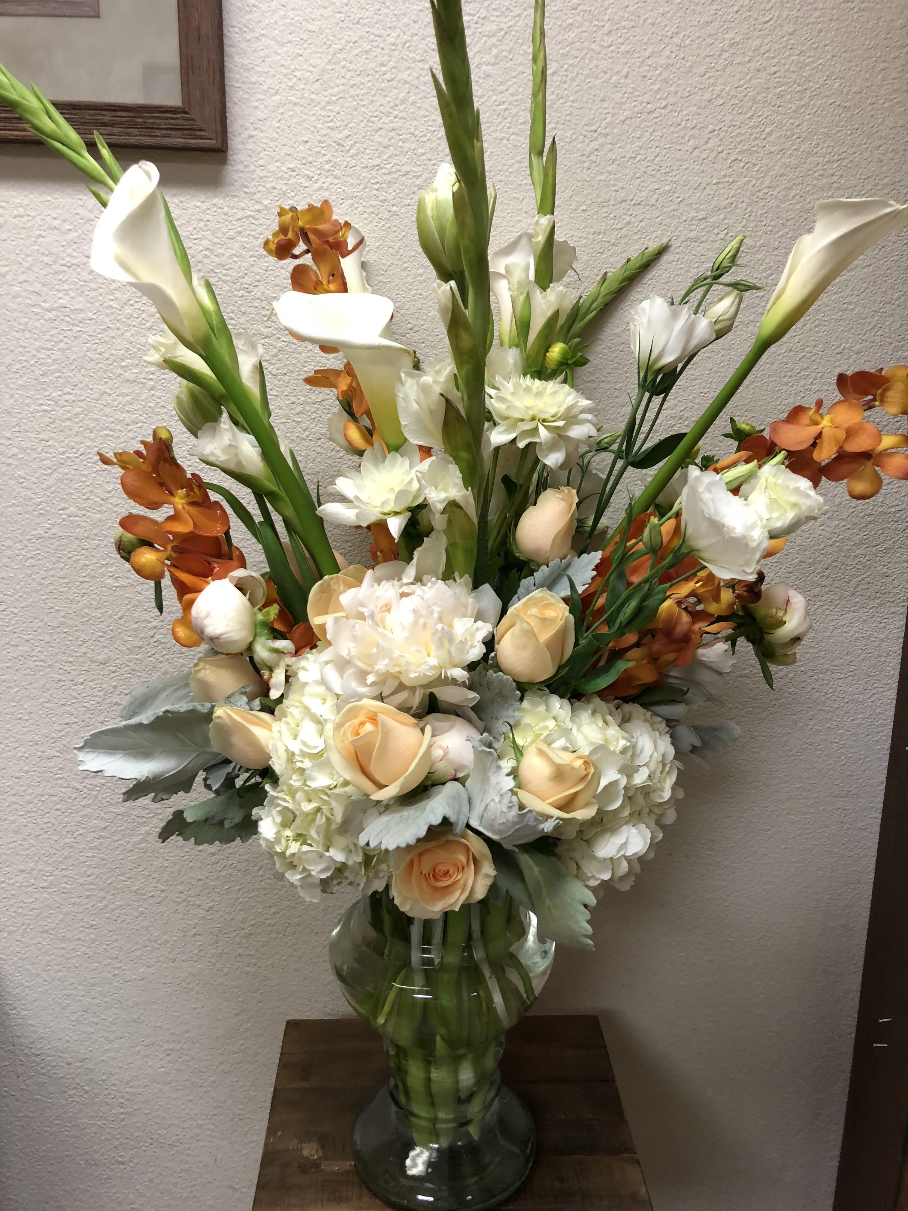 Florence, Italy - Recipe: Seasonal Dahlias, Seasonal Peonies, Orange Dendrobium Orchids, Calla Lilies, Roses, Lisianthus, Hydrangae, White Gladiolas, and Dusty Miller in a tall vase. Season: Seasonal Dahlias Orientation: Front Facing View Photo shown: Standard