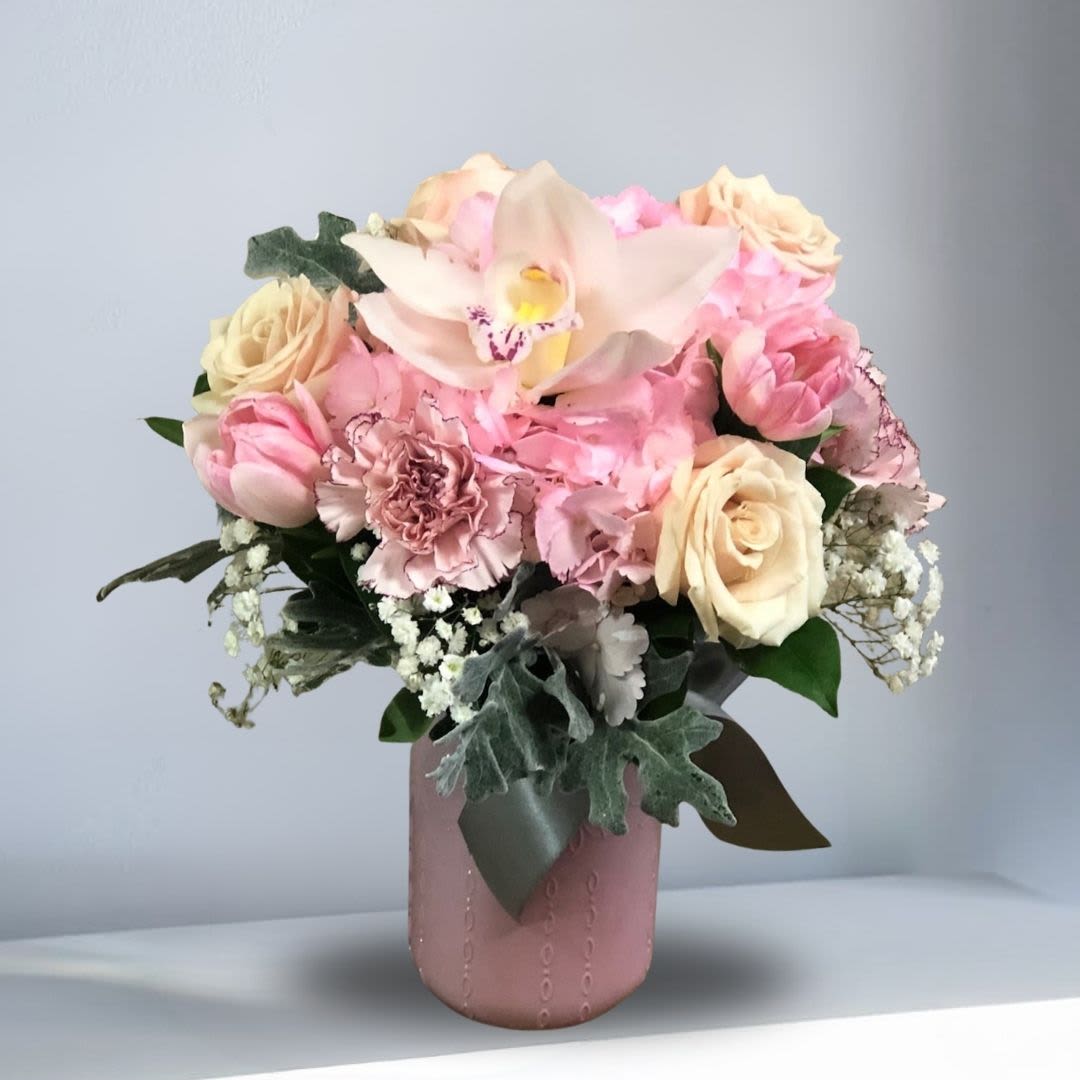 Welcome Joy of Life - Type of Flowers: Pink Hydrangeas, White Cymbidium Orchids, Pink Tulips, White Spray Roses, Pink Carnations, Dusty Miller and Baby Breath in a pink vase. Availability: All year round Substitute Available: Yes Design View: All Facing View Photo shown: Regular 