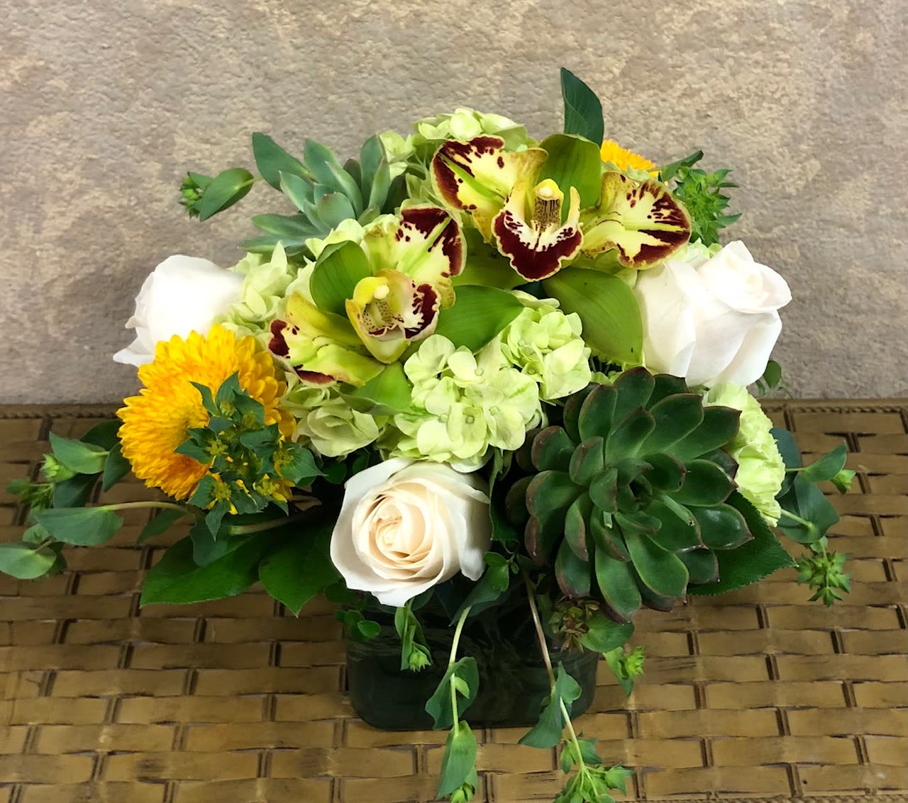 Nashville, Tennessee - Type of Flowers: Yellow Chrysanthemums, Green Orchids, Green Hydrangea, White Roses, and Succulents in a leaf-wrapped vase. Availability: All year round Design View: All Facing View Photo shown: Standard 