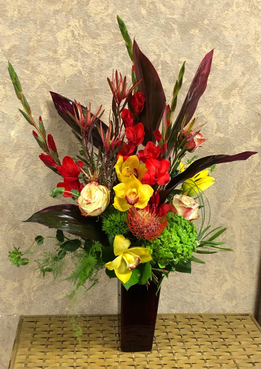 Fire in my heart - Type of Flowers: Red Gladiolas, Green Cymbidium Orchids, Yellow Roses, Yellow Asiatic Lilies, Green Hydrangea, Red Pin Cushion Protea, Green Buttons, Dianthus barbatus Availability: All year round Substitute Available: Yes Design View: Symmetric Front Facing View Photo shown: Standard