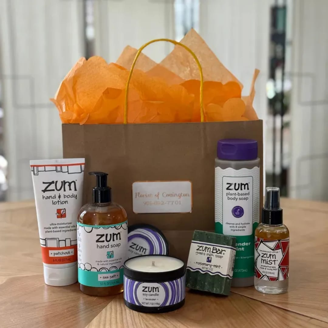 Gift bag with orange tissue paper and assorted Zum bath products