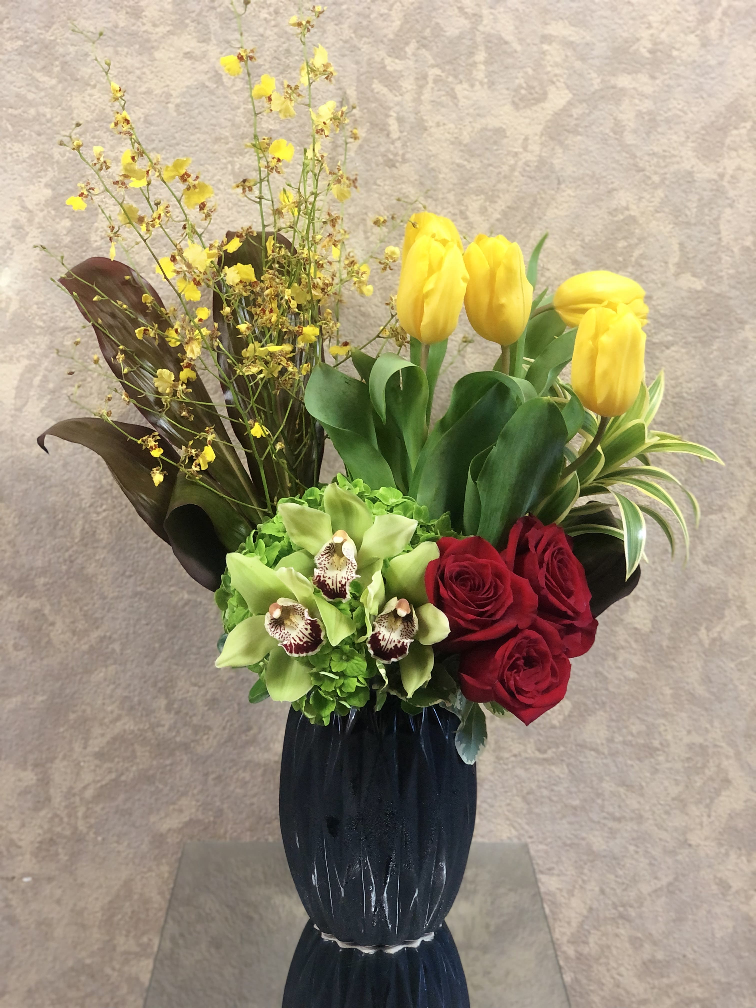 Road to Hana NEW - Recipe: Tropical Oncidium Orchids, Roses and Tulips in a black geometric vase. VASE NO LONGER AVAILABLE WILL SUBSTITURE FOR SOMETHING SIMILAR