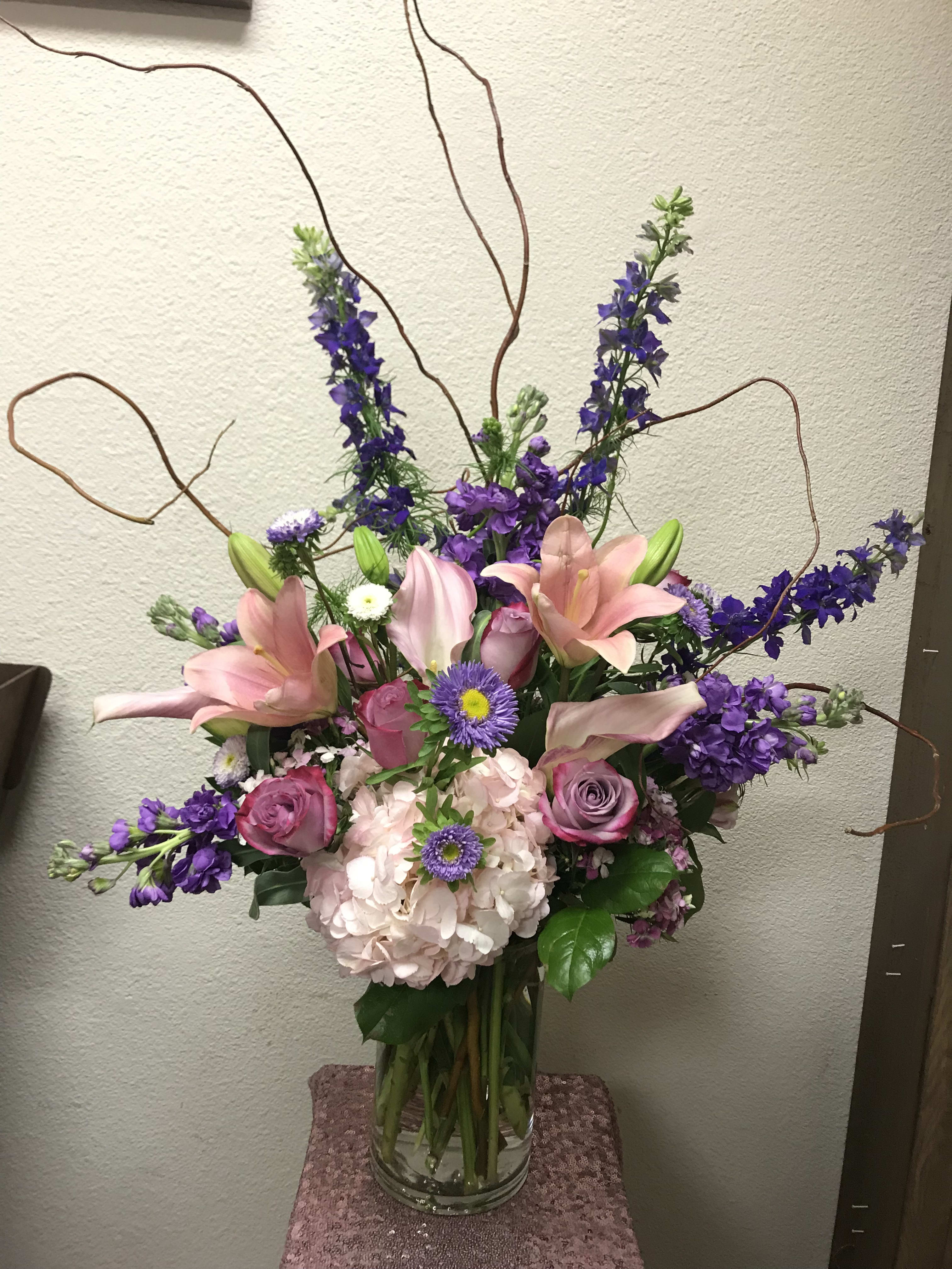 Free Spirit - Type of Flowers: Calla Lilies, Roses, Larkspur, Hydrangea, Stock, Branches and more in a tall vase. The photo shown is a Regular. Availability: All year round 