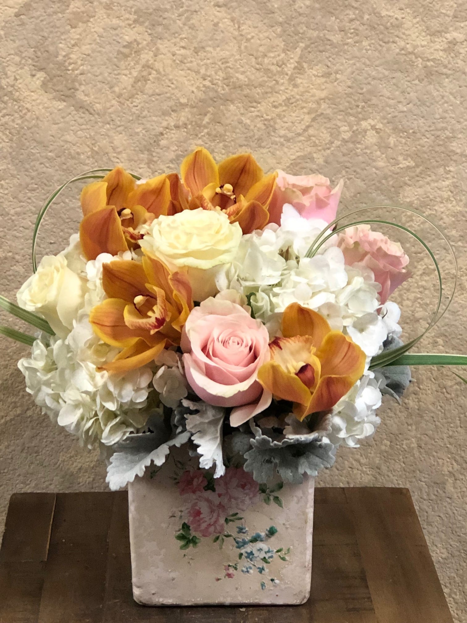 London - Type of Flowers: Cymbidium Orchid, Hydrangeas, Roses and Dusty Miller in a 6” x ^" square ceramic vase with pink roses. All-year-round: Yes Substitute Available: Yes