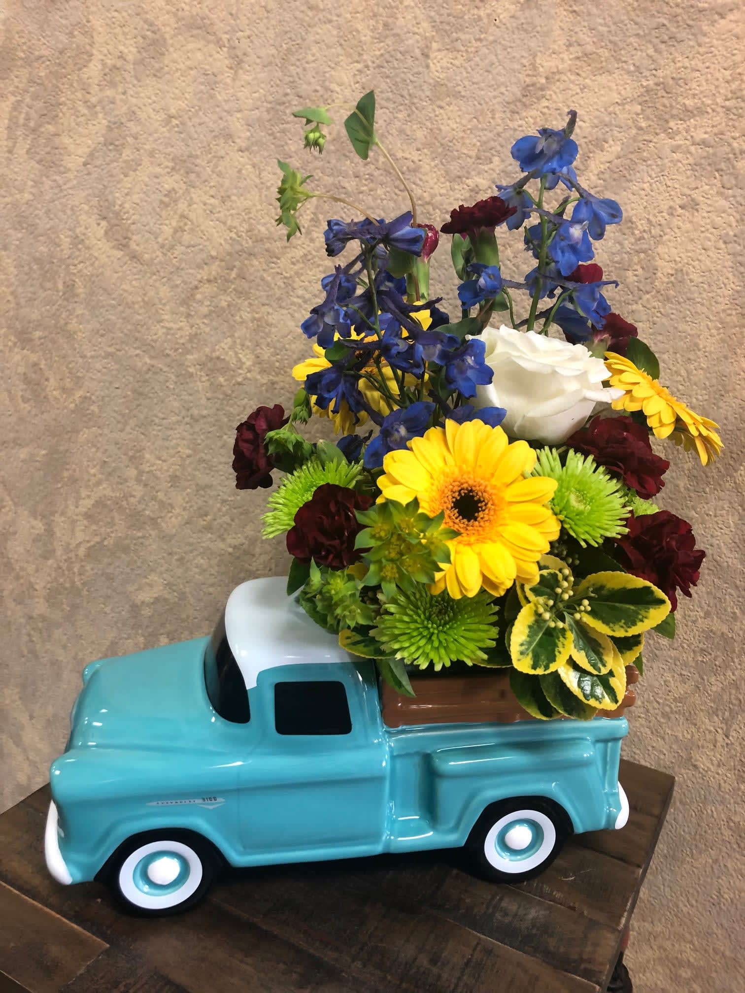 Classic Chevy Pick-Up - Dad’s sure love this!! Hand painted - glazed ceramic.  Commemorating the 100th anniversary of Chevy truck .  Blue delphinium, green button chrysanthemums. Yellow Gerbera daisy, white rose.