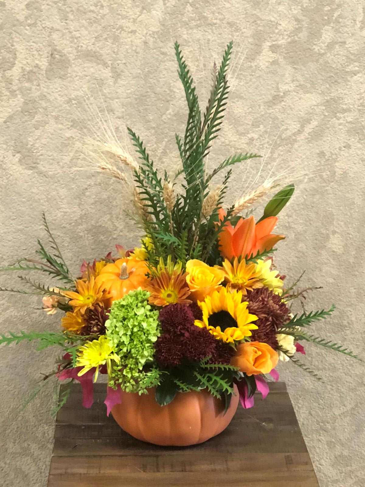 Pumpkin Kisses, Harvest Wishes - Type of Flowers: Sunflowers, Orange Roses, Orange Asiatic Lilies, Green Hydrangeas, Fall colored daisies and more in a NATURAL pumpkin vase. Availability: All year round Substitute Available: Yes Design View: Symmetric Front Facing View Photo shown: Regular