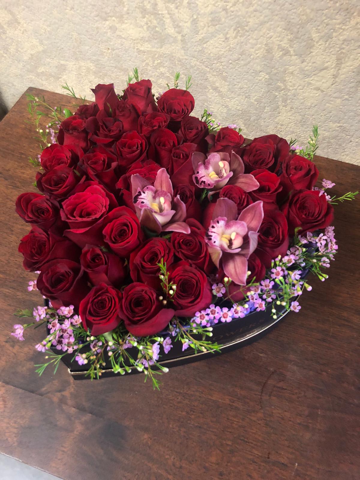 Heart-Shaped box with Red Roses *displaying premium picture* - (displaying premium picture) (available in all colors) Type of Flowers: Red Roses and Purple Cymbidium Orchids in a heart-shaped box. Availability: All year round Substitute Available: Yes Design View: All Facing View Photo shown: Premium