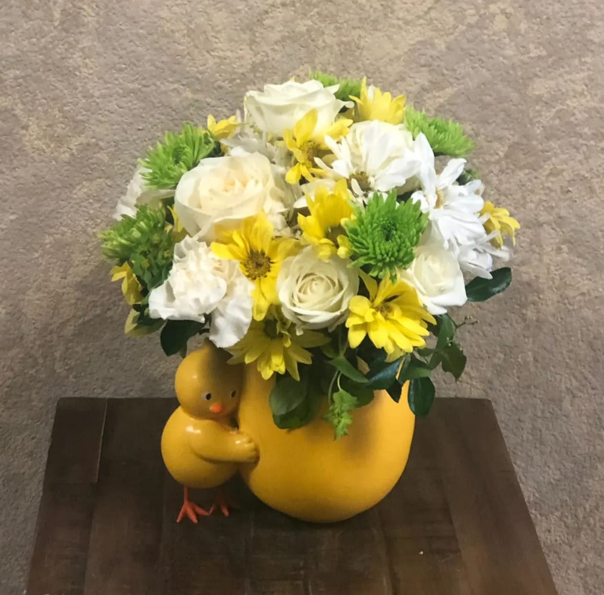 Hello Baby Chic - Type of Flowers: White Roses, Yellow Daisies, White Daisies, White Mini Carnations, and Green Chrysanthemums in a ceramic egg with a baby chic. Availability: All year round Substitute Available: Yes Design View: Symmetric Front Facing View Photo shown: Regular 