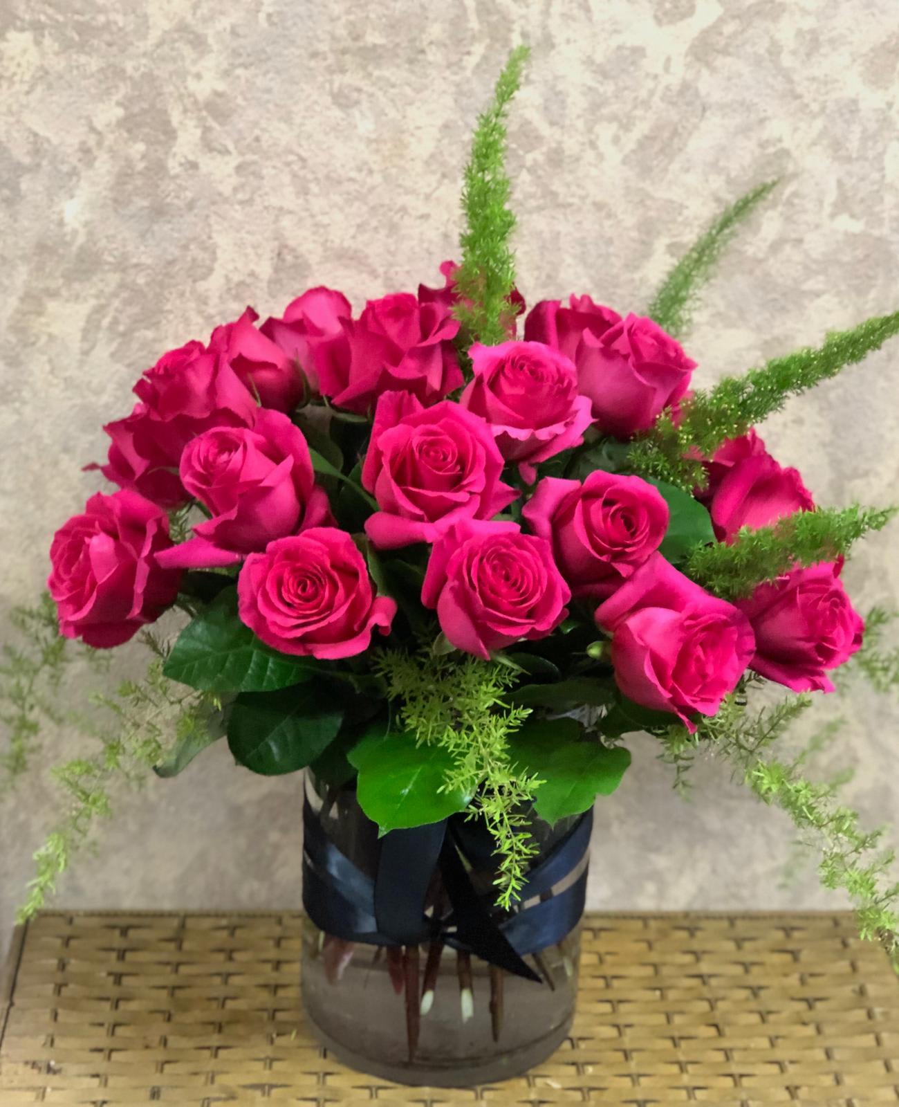 California's Hot Summers Roses - Recipe: 25 Hot Pink Roses and Fern in a short vase wrapped in black ribbon. Season: All year round Orientation: All Facing View Photo shown: Standard 