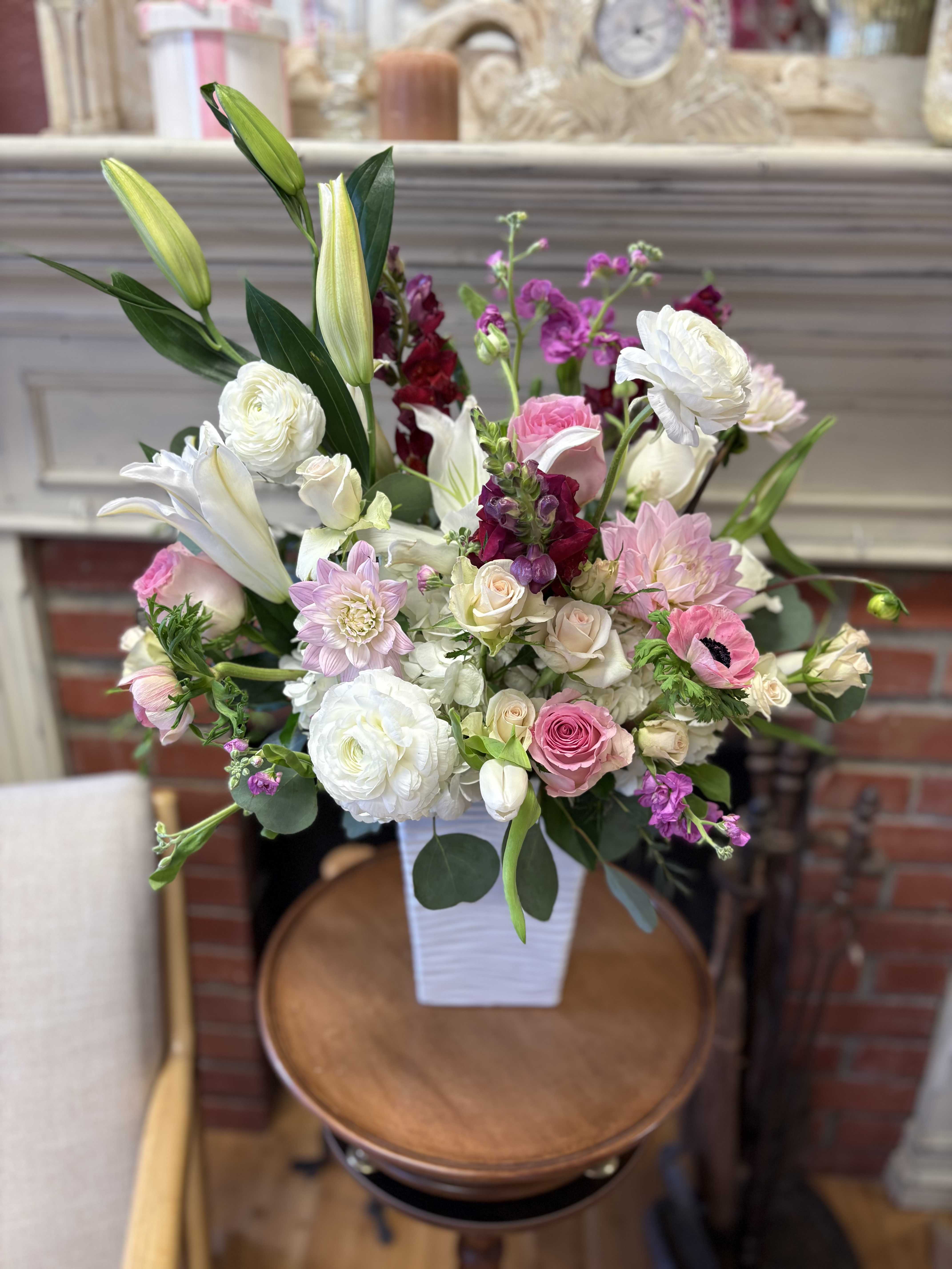Mixed pink and white flower arrangement in a white vase