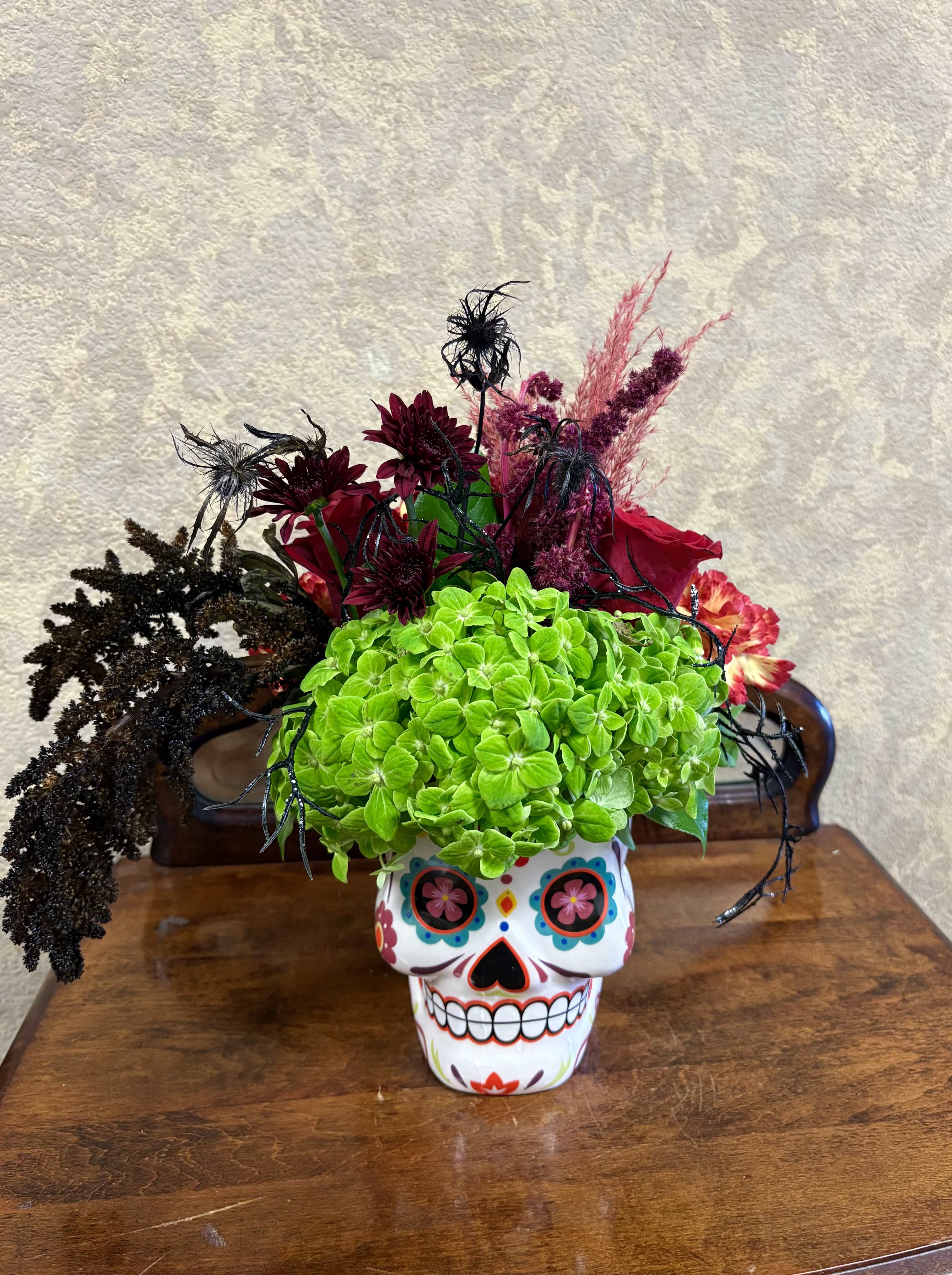 La Catrina - Type of Flowers: Red roses, Green Hydrangeas, Scabiosa, Amaranthus Caudatus, Celosia Cockscomb in a coffee mug. Availability: Limited coffee mug available.  Substitute Available: Yes Design View: All Facing View Photo shown: Regular 