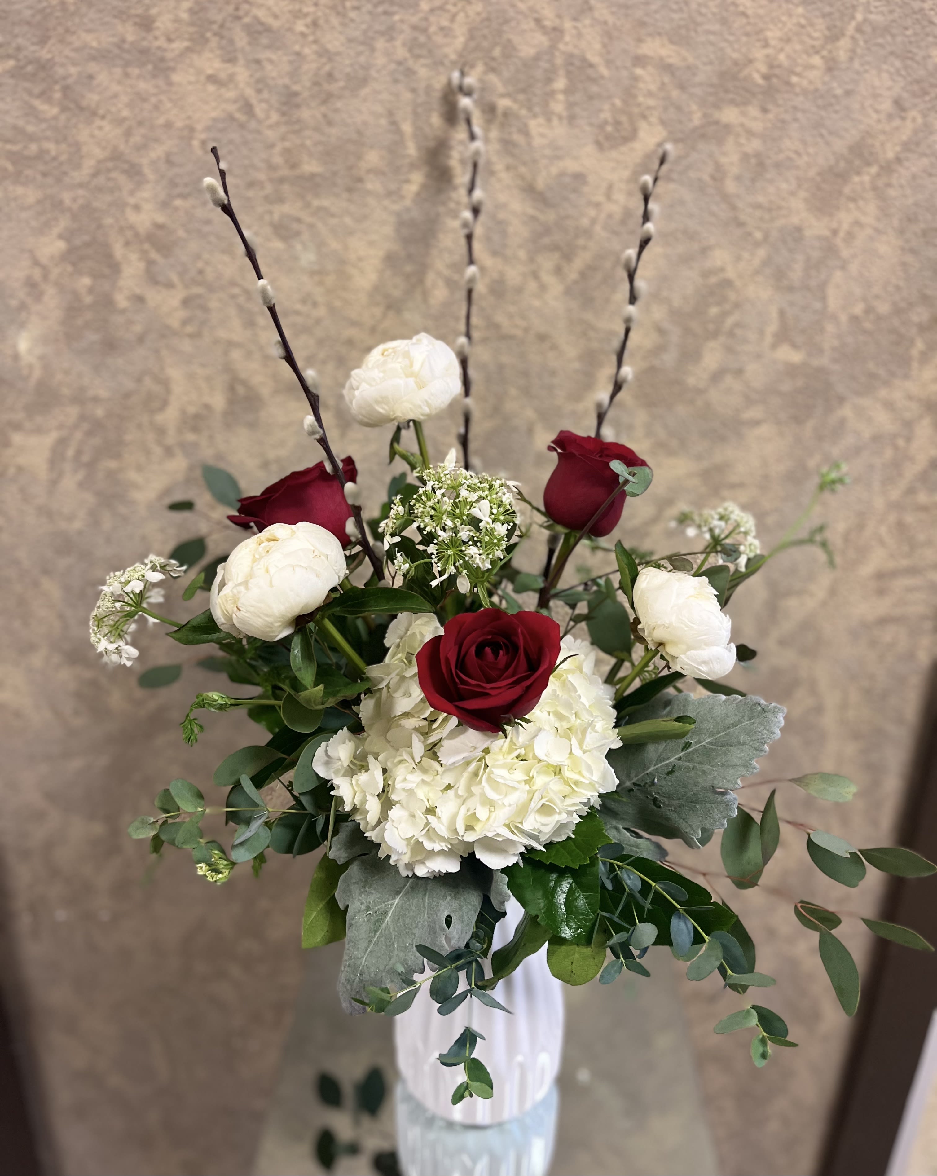 PS I love you - Type of Flowers: White Peonies, Red Roses, Pussy Willow, and Eucalyptus in a short, white vase. Season: Peonies seasonal November to mid Summer Design View: Symmetric Front Facing View Photo shown: Standard 