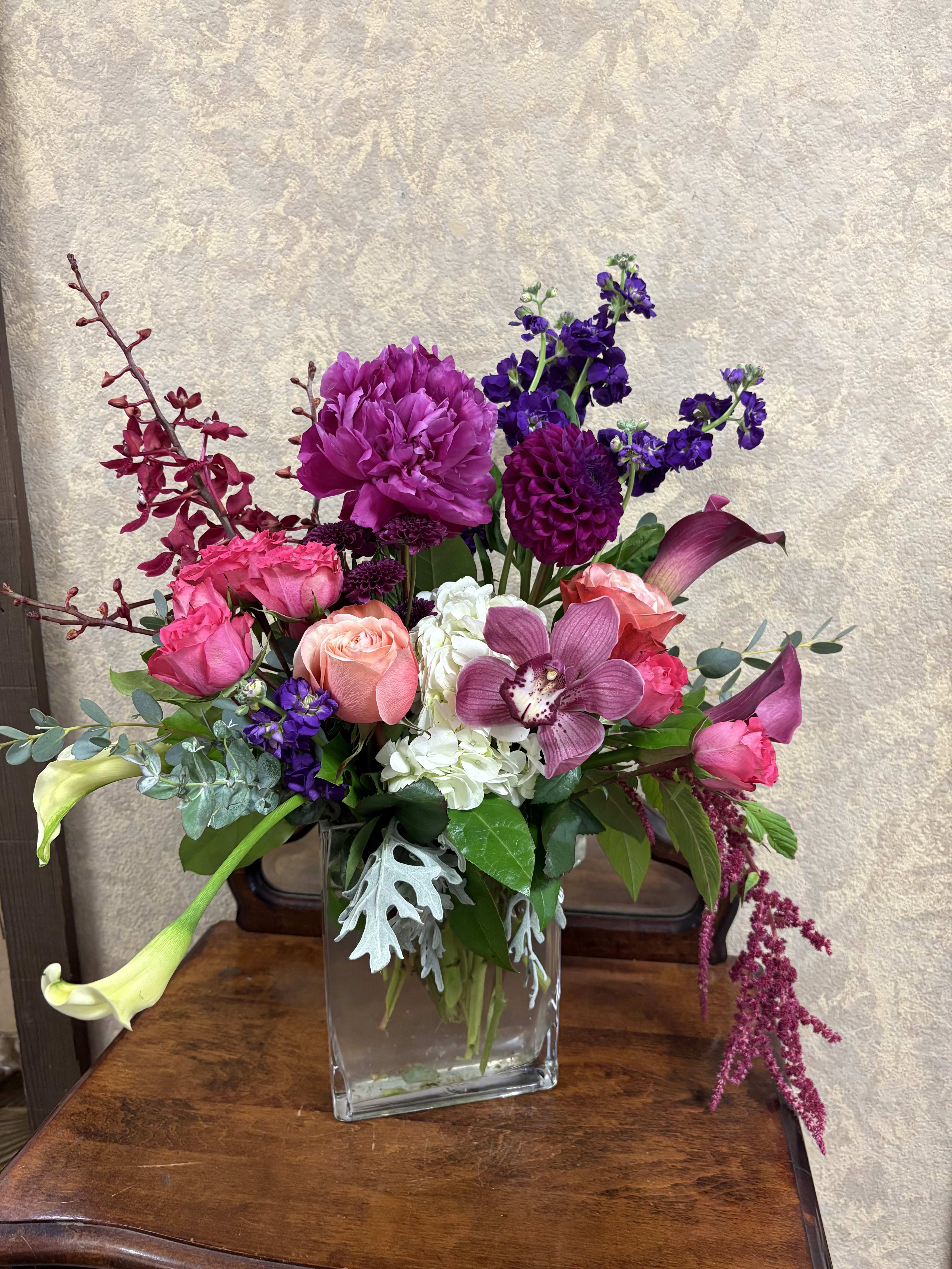Lady Luxe - This lush and vivid arrangement contains all premium flowers that will blow them away! Recipe: Peonies, Orchids, Dahlias, Hydrangeas, Roses, Stock, Calla Lilies, Amaranthus, and more in a tall clear vase. Availability: Seasonal Peonies and Dahlias Design View: Symmetric Front Facing View Photo shown: Standard
