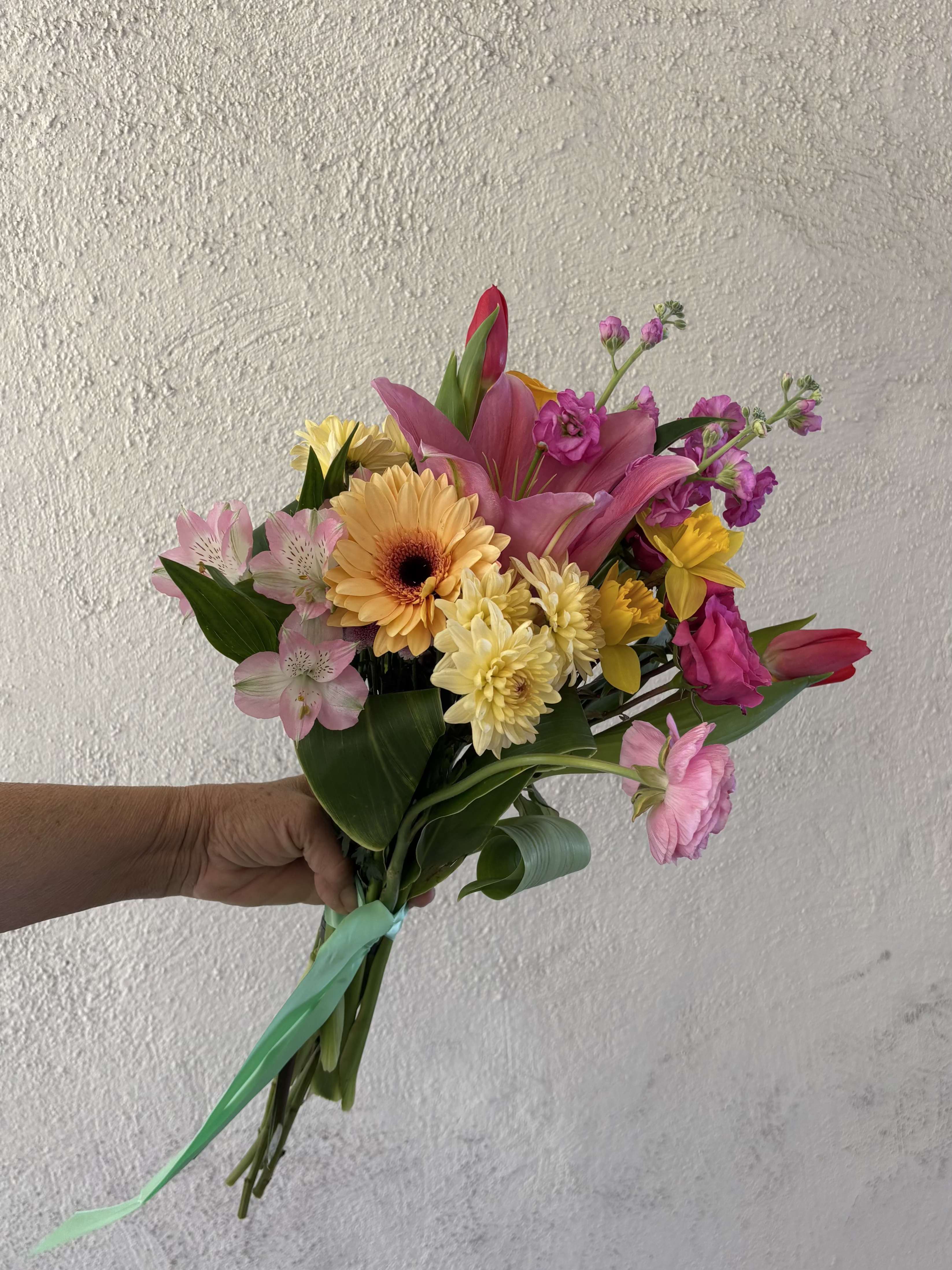 FRESH DROP NO 7 - Our Spring Fresh Drop has a pop of color! With seasonal rancunclus and daffodils, yellow chrusanthemums, red tulips, hot pink spray roses, gerbera daisies, stock and more!