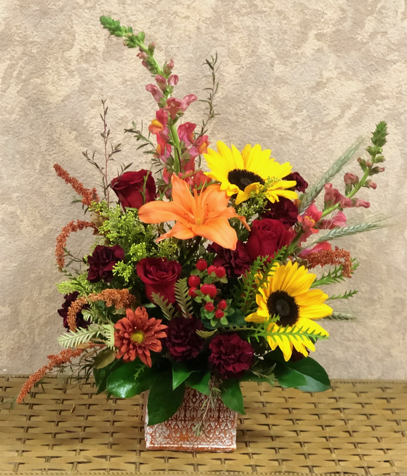 Give Thanks - Type of Flowers: Red roses, Pink Snapdragons, Amaranthus, Daisies, Lilies, Sunflowers, Hypericum Berries, and more in a gold, patterned vase. Availability: All year round Substitute Available: Yes Design View: Symmetric Front Facing View Photo shown: Regular