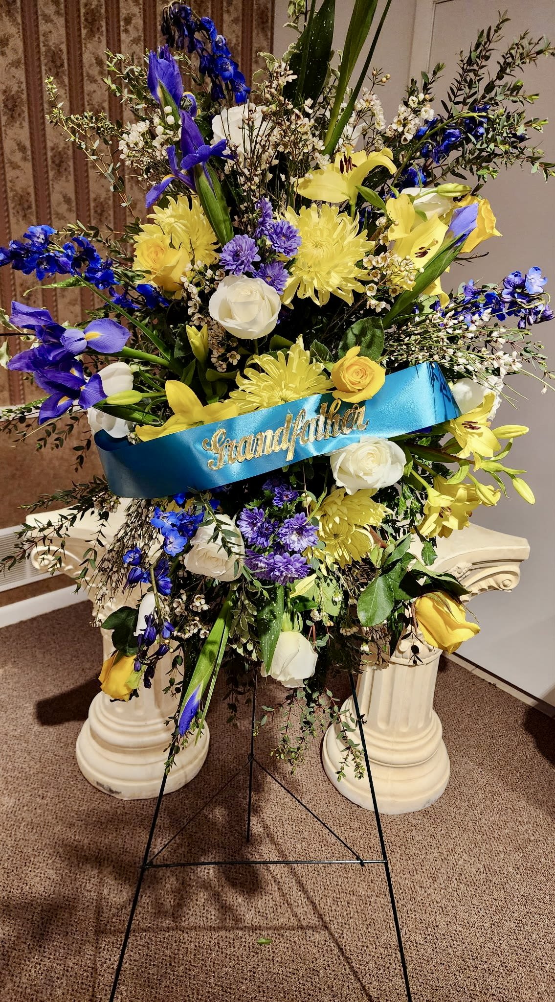 Large standing floral spray with a blue "Grandfather" ribbon