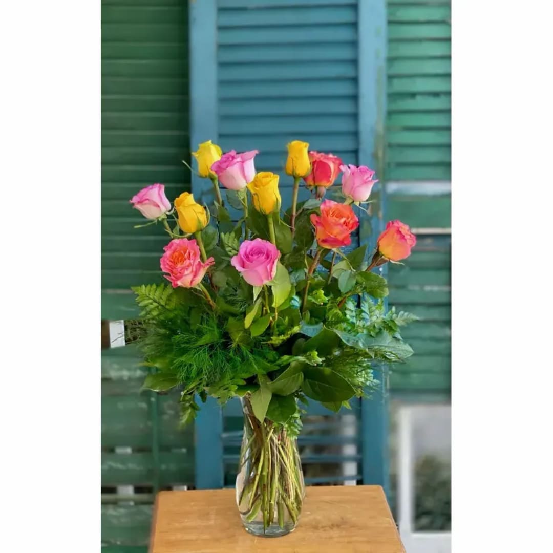 Mixed pink and yellow roses in a clear glass vase