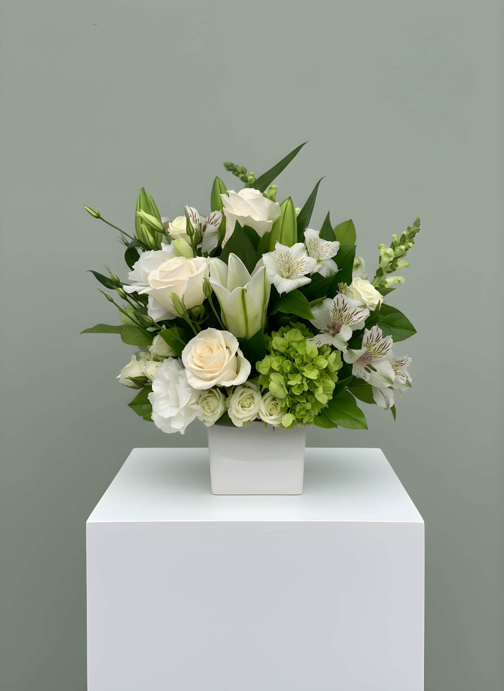 LF116 - Peaceful Wishes - A mixed bouquet of green and white flowers to include white lilies, green hydrangea, and other seasonal flowers. This arrangement is all about elegance and tranquility.