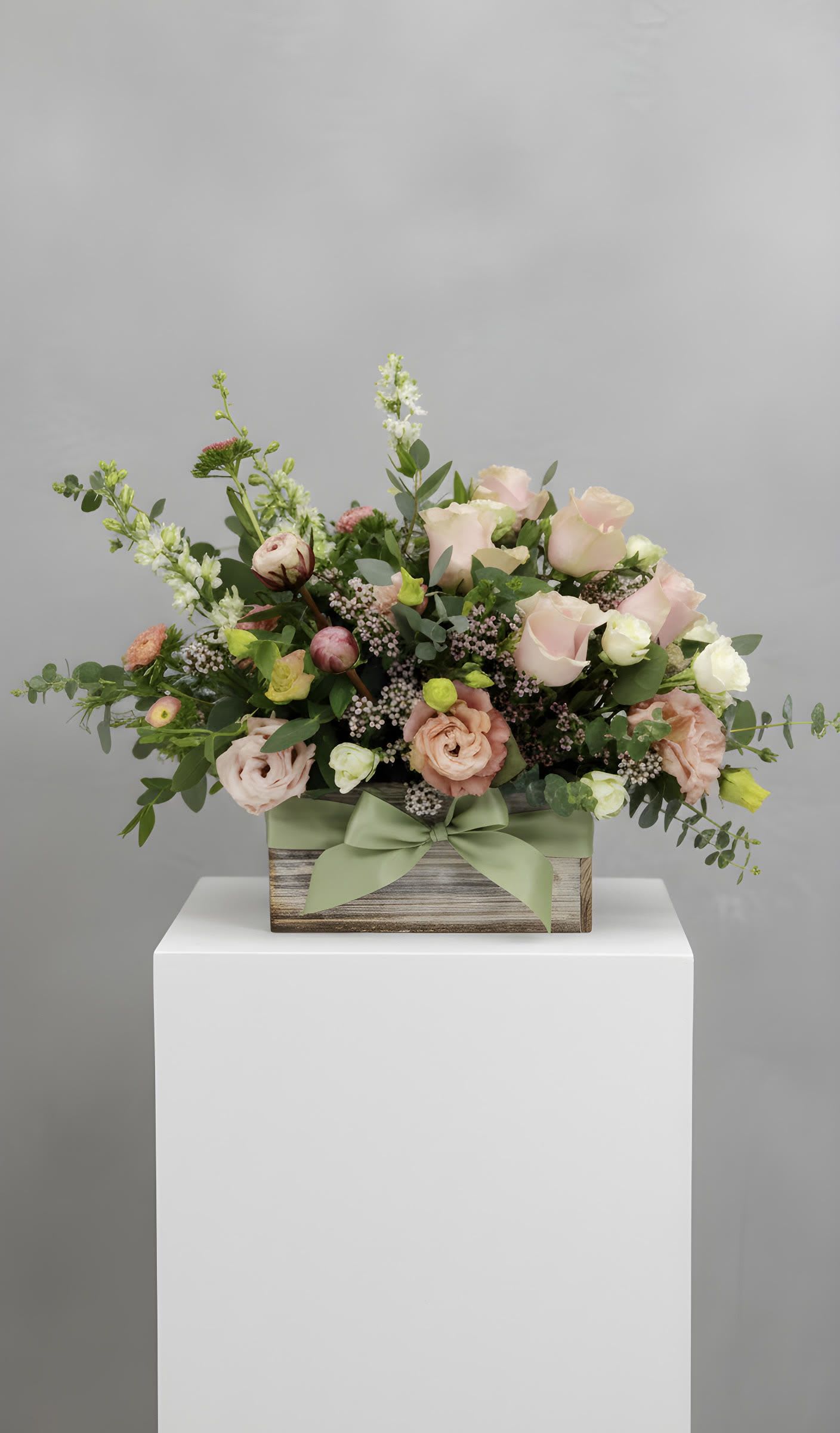 LF351  PURE JOY - Who wouldn't want to receive this gorgeous mix of baby pink roses arranged in a rustic white washed box?  All this grouped with seasonal premium flowers, and finished off with a sage green satin bow. Peonies are seasonal and may not be available during certain times of the year.   Orientation:  All around