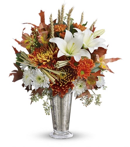 Tall autumn arrangement with white lilies and orange and white chrysanthemums in a silver vase
