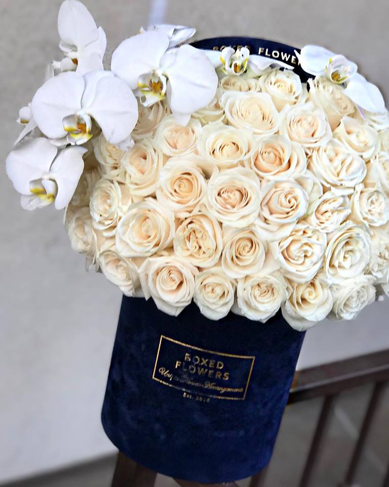 Bouquet of cream roses with white orchids in a navy wrap