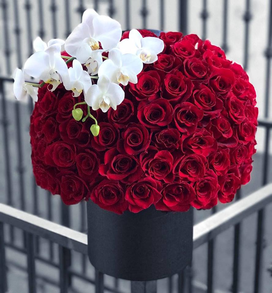 Red rose arrangement with white orchids in a black box