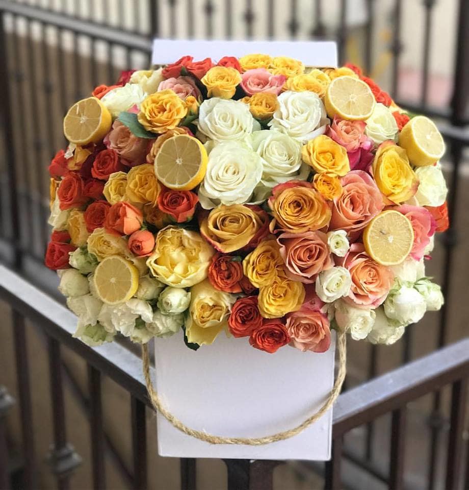 Bouquet of multicolored roses with lemon slices on a white backing