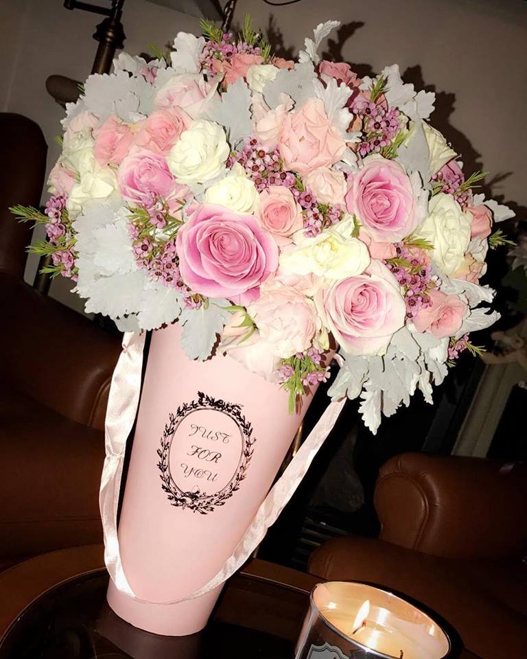 Pink and white rose bouquet in a pink cone wrap with ribbon