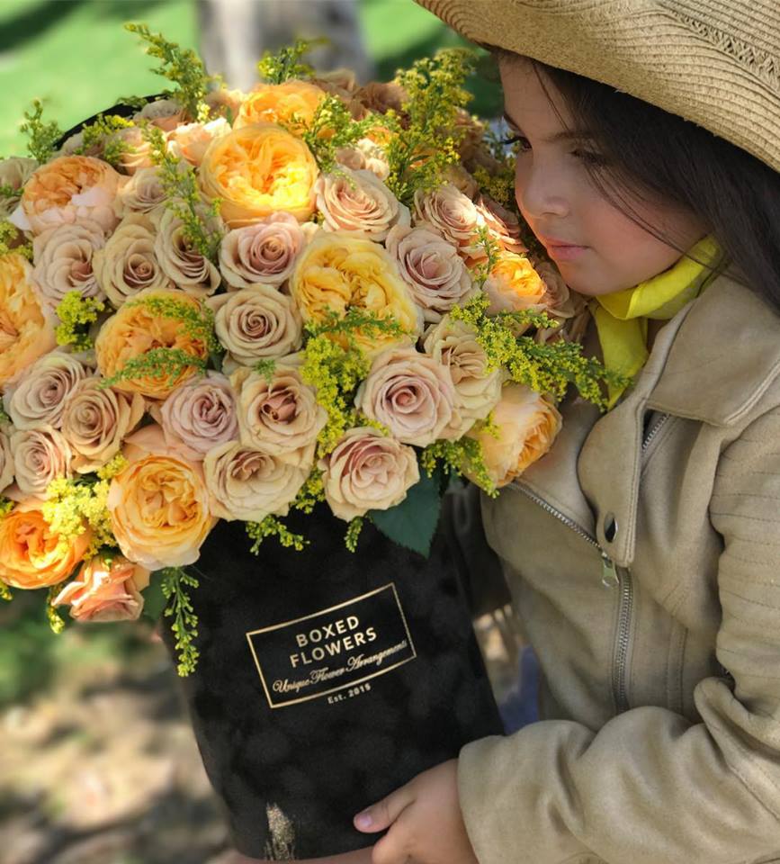 Large bouquet of peach and cream roses in a black box