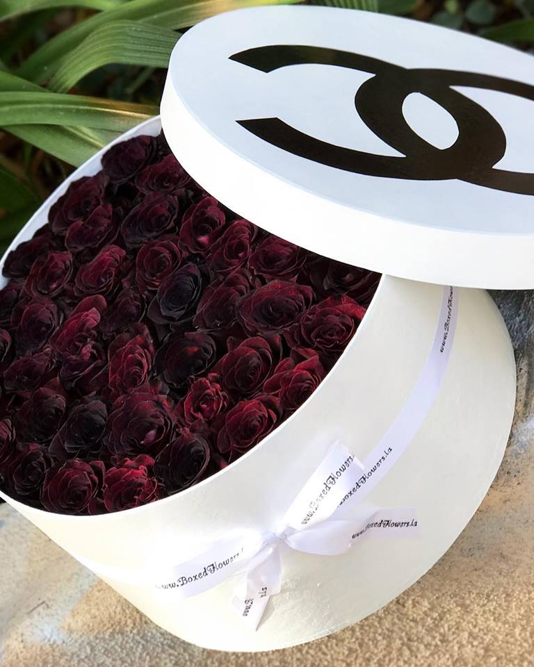 Box of dark red roses with a white lid and ribbon