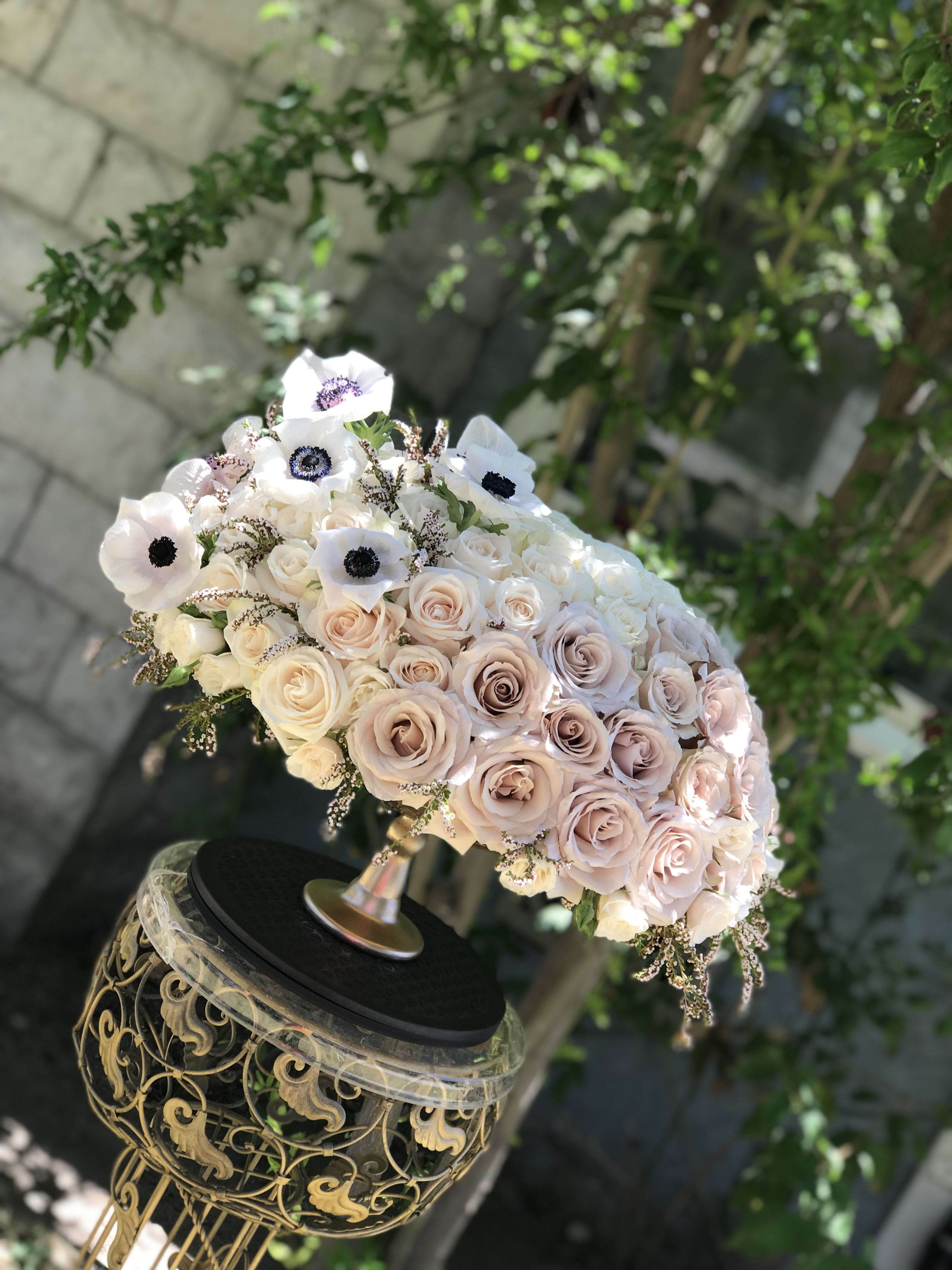 Blush and white rose bouquet with white anemones on an ornate stand
