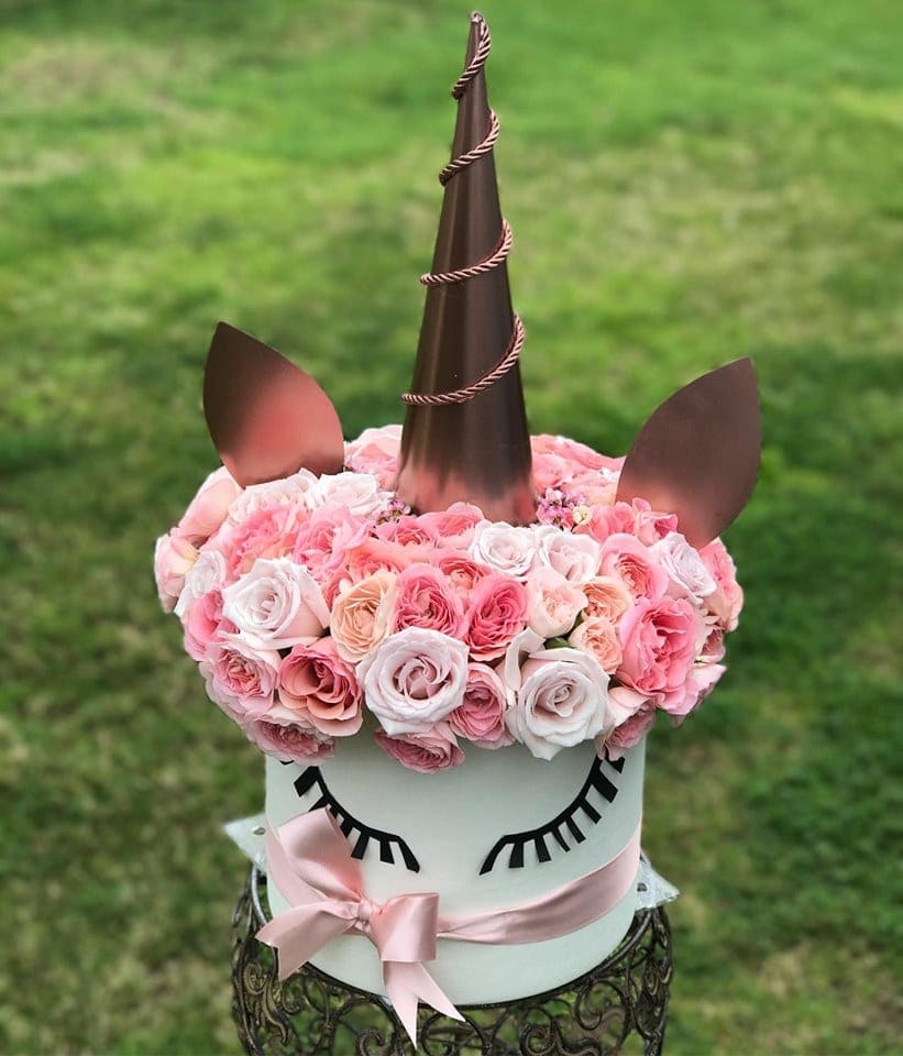 Unicorn-shaped floral arrangement with pink roses and a ribbon bow