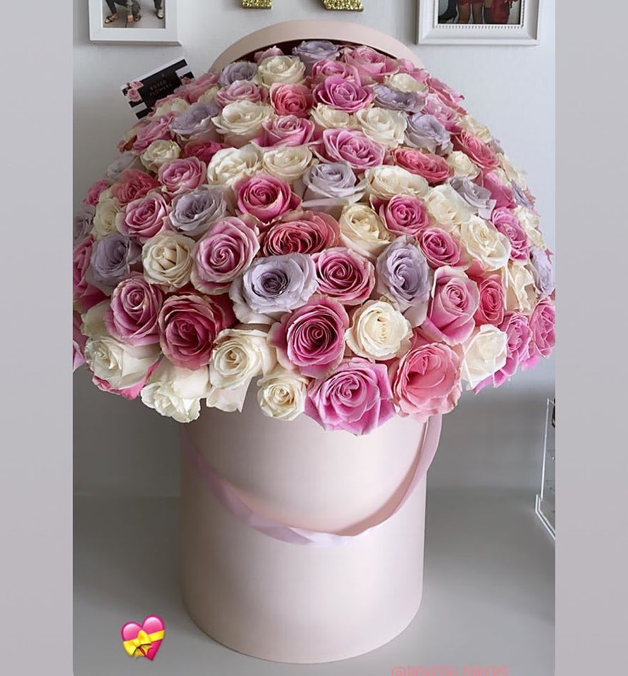Large round bouquet of pink, white, and lavender roses in a pale pink hat box