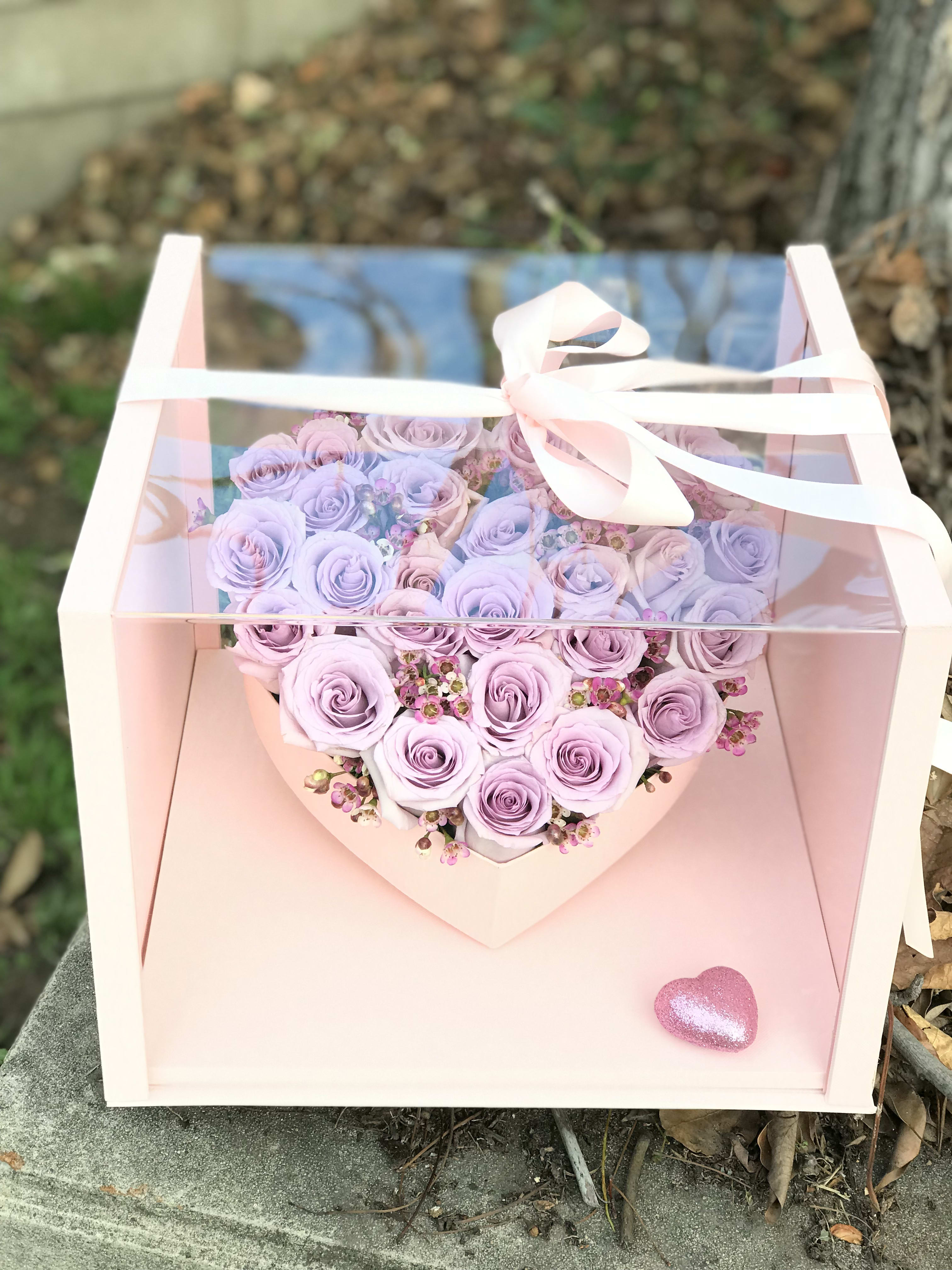 Lavender rose bouquet in a pink gift box with a ribbon bow