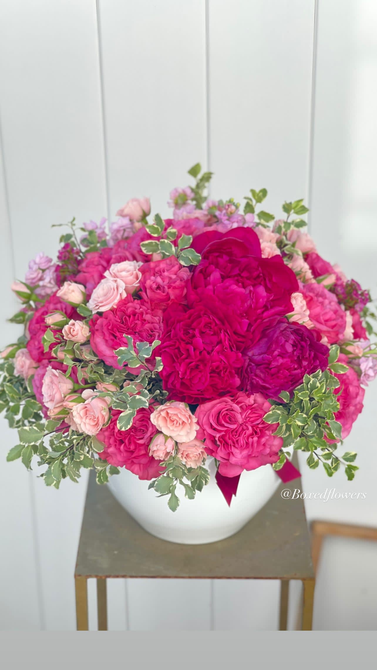 Pink and magenta rose bouquet in a white vase