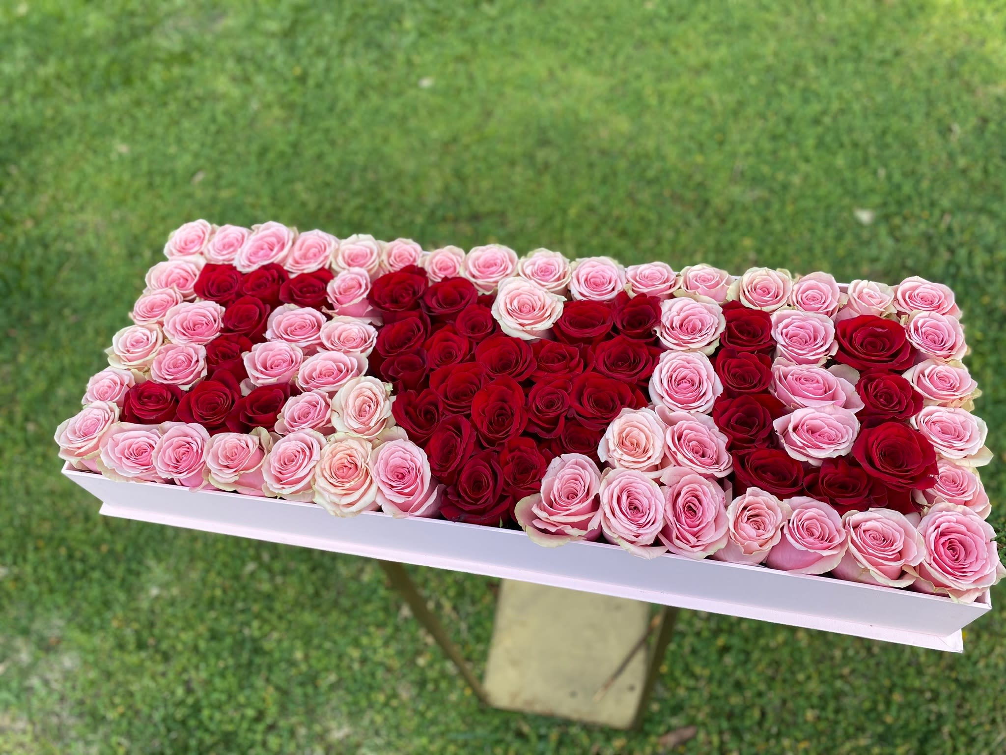 Rectangular box arrangement of red and pink roses